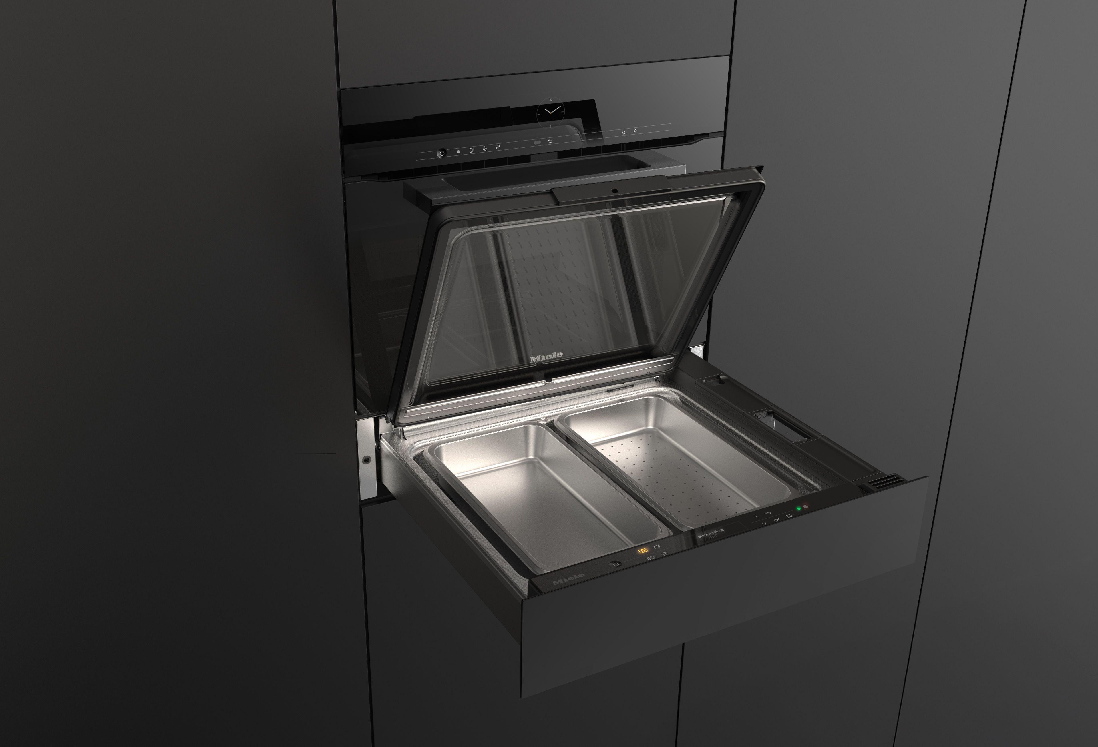 Leere Miele Dampfgarer-Schublade mit zwei Edelstahl-Garbehältern und geöffnetem Deckel.